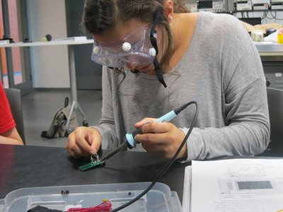 Student soldering with soldering iron