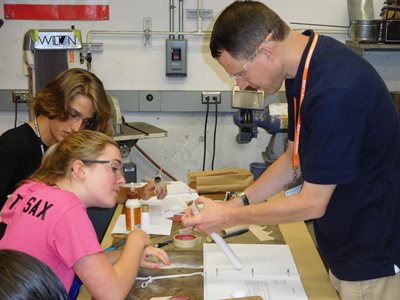 IAI Campers working in a lab with a TA to construct models
