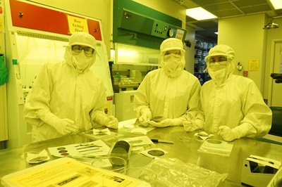 Campers dressed in protective suits, working in a clean room 