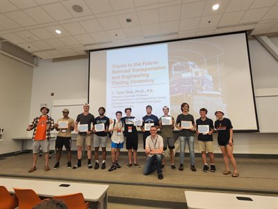 Campers standing on stage, displaying their certificates