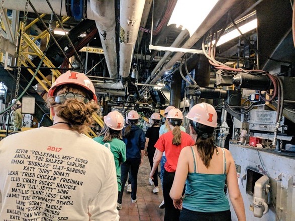 Campers walking through lab space wearing hard hats