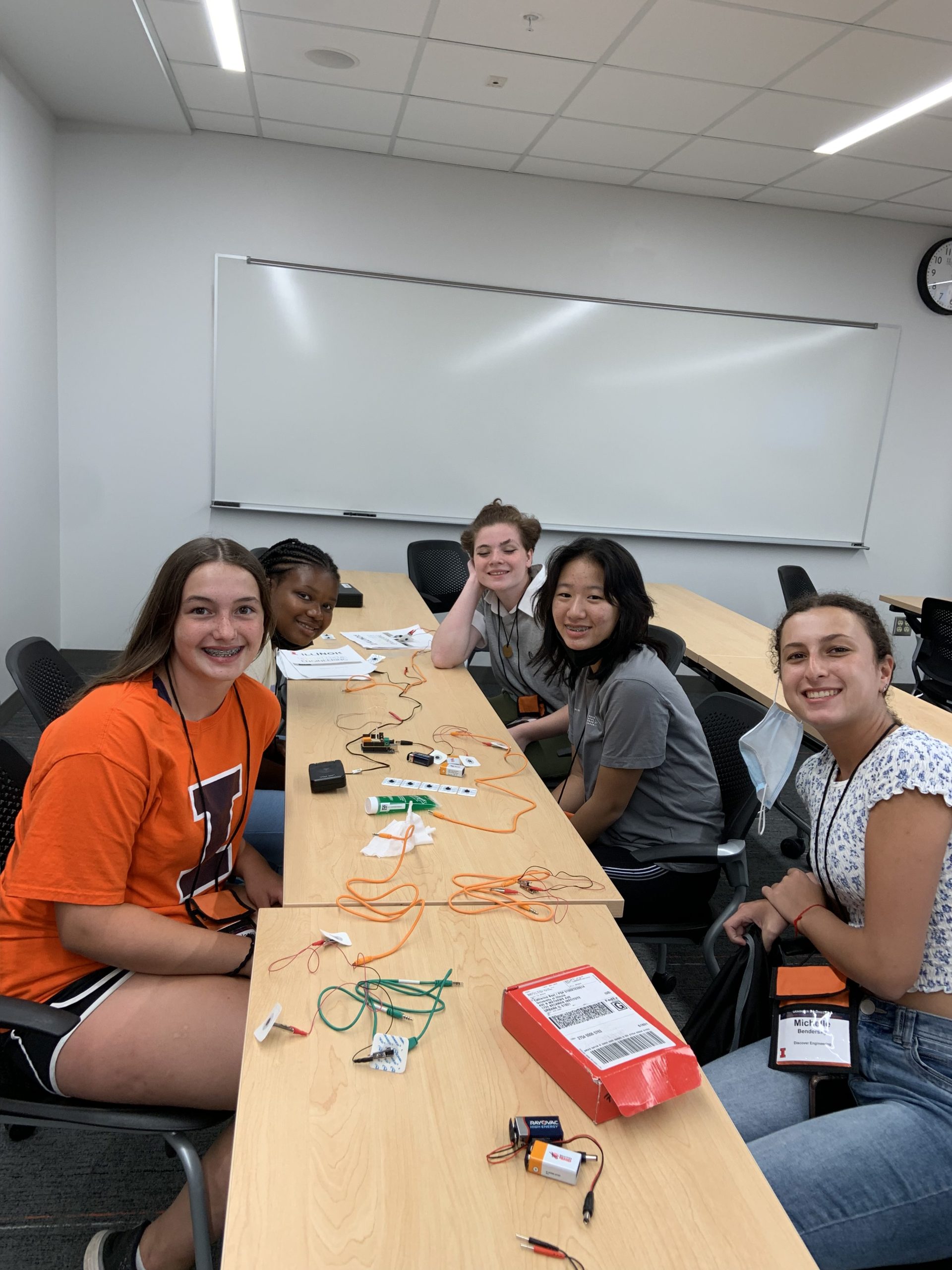 Campers sitting around table learning about circuit components