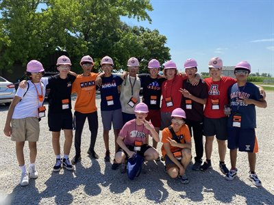 Campers posing for photo wearing hard hats