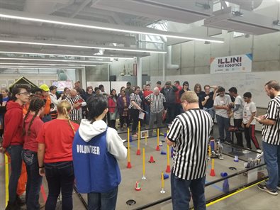 FIRST Illinois Robotics Competition showing robots field with volunteer and attendees at the University of Illinois at Urbana-Champaign in November 2022
